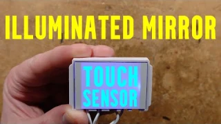 Illuminated touch sensor for mirrors and other surfaces